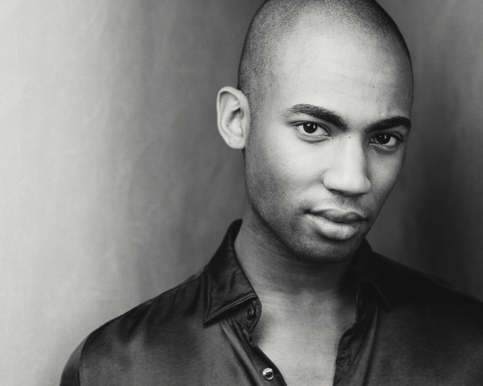Dramatic black and white portrait photo of black male with a light background Dramatic black and white portrait photo of black male with a light background