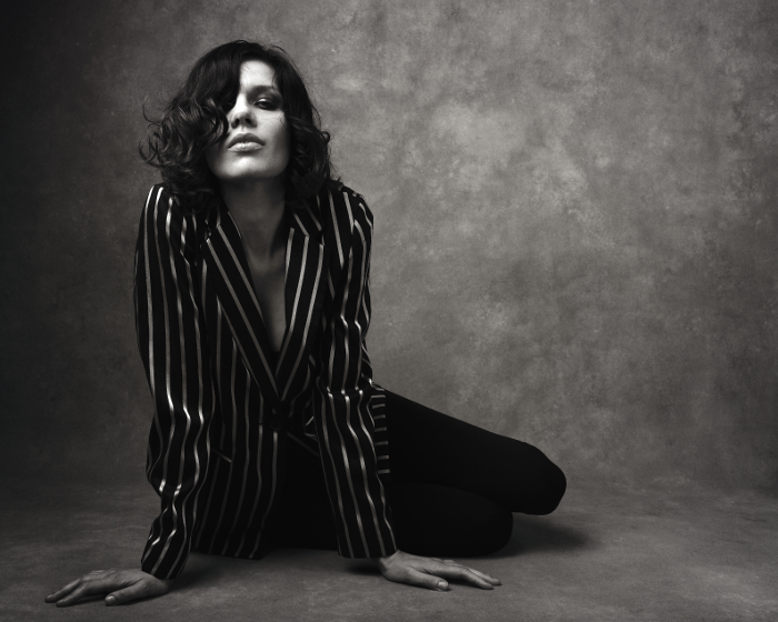 Black and white fashion portrait of women sitting on the floor wearing a pin stripe jacket. Black and white fashion portrait of women sitting on the floor wearing a pin stripe jacket.