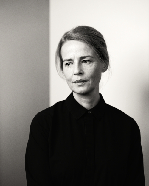 Low key black and white portrait photograph with light background of women in dark clothing, looking off camera. Low key black and white portrait photograph with light background of women in dark clothing, looking off camera.