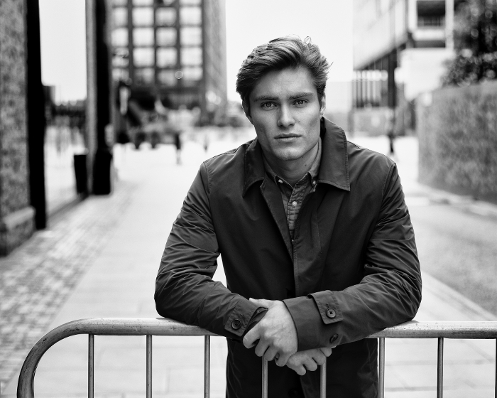 Dark outside black and white portrait photo of white male leaning on a railing. Dark outside black and white portrait photo of white male leaning on a railing.
